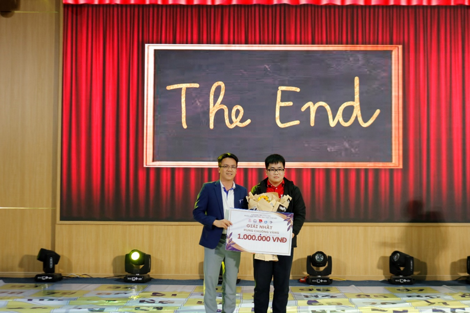 Two men standing in front of a stage with a sign

Description automatically generated